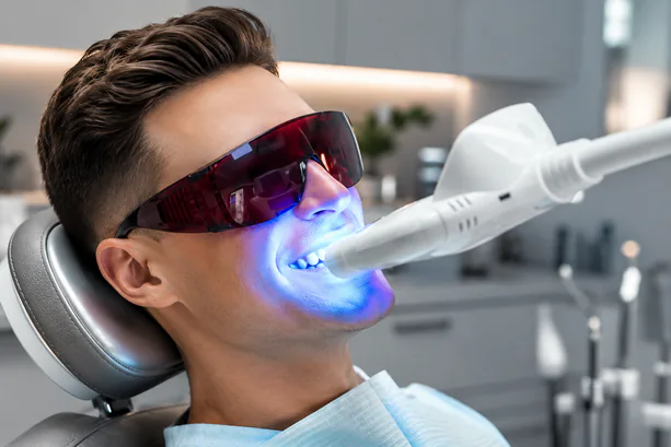 man receiving teeth whitening in dental office